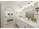 Modern bathroom featuring double vanity, quartz countertops, and matte black fixtures plus a view of the main bedroom at 460 Daylily Blvd, Nokomis, FL 34275
