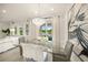 Open dining area with a modern glass table, chandelier, and access to an outdoor view at 460 Daylily Blvd, Nokomis, FL 34275
