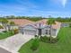 Beautiful single-Gathering home featuring a tile roof, well-manicured lawn, and a paver driveway leading to a three-car garage at 460 Daylily Blvd, Nokomis, FL 34275