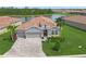 Beautiful single-story home with lush landscaping, paver driveway, and two-car garage at 460 Daylily Blvd, Nokomis, FL 34275