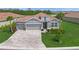 Well-manicured home featuring a 3-car garage and paver driveway at 460 Daylily Blvd, Nokomis, FL 34275