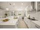 Bright, modern kitchen with island, white cabinets, pendant lights and open floor plan at 460 Daylily Blvd, Nokomis, FL 34275