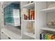 Close up of a TV above a bookshelf with a few books at 460 Daylily Blvd, Nokomis, FL 34275
