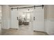 Elegant living room beyond sliding barn doors, featuring stylish decor, tiled floor and a comfortable gray sofa at 460 Daylily Blvd, Nokomis, FL 34275
