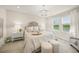 The bedroom features a soft color palette, chandelier lighting, and serene views of the lake at 460 Daylily Blvd, Nokomis, FL 34275