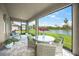 The screened lanai features comfortable seating and a table with a serene view of the lake at 460 Daylily Blvd, Nokomis, FL 34275