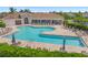 Community pool with lounge chairs and umbrellas, surrounded by lush landscaping at 460 Daylily Blvd, Nokomis, FL 34275