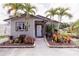 Charming home with lush landscaping, a brick walkway, and tropical palm trees at 4945 Camphor Ave, Sarasota, FL 34231