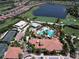 Aerial view of a community pool, golf course, tennis courts, and residential homes in a beautiful Primary-planned community at 4949 Savona Run, Bradenton, FL 34211