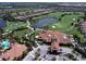 Aerial view of the country club showcasing the golf course, clubhouse, swimming pool, and residential area at 4949 Savona Run, Bradenton, FL 34211