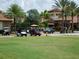 View of the clubhouse with available golf carts parked outside the entryway and mature landscaping at 4949 Savona Run, Bradenton, FL 34211