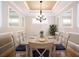 Bright dining room featuring wood floors, stylish chandelier, and seating for six at 4949 Savona Run, Bradenton, FL 34211
