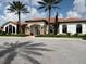 Stately community building with a tile roof, stone accents, and lush landscaping creates a welcoming impression at 4949 Savona Run, Bradenton, FL 34211