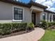 Inviting front entrance with a brick walkway, covered entry, and neatly trimmed hedges at 4949 Savona Run, Bradenton, FL 34211