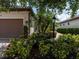 Landscaped front yard with vibrant flowers, trees, and manicured hedges creating a welcoming curb appeal at 4949 Savona Run, Bradenton, FL 34211