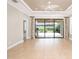 Spacious living room with tile floors, crown molding, and large sliding doors to the outdoor patio at 4949 Savona Run, Bradenton, FL 34211