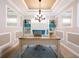 Charming home office with bright light, tray ceiling, custom built-ins, and hardwood floors at 4949 Savona Run, Bradenton, FL 34211