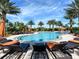 Resort-style pool with lounge chairs and umbrellas, perfect for relaxation under the palm trees at 4949 Savona Run, Bradenton, FL 34211