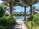 Lushly landscaped walkway to a luxurious pool area with palm trees and comfortable seating at 4949 Savona Run, Bradenton, FL 34211
