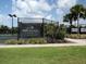 A community tennis court at Esplanade Golf & Country Club, featuring beautiful landscaping and a clear sign at 4949 Savona Run, Bradenton, FL 34211