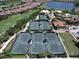 Aerial view of well-maintained tennis courts surrounded by green landscaping in a beautiful residential community at 4949 Savona Run, Bradenton, FL 34211