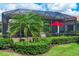 The landscaped backyard has a covered patio with lush plants, creating a relaxing outdoor space at 5117 Serata Dr, Bradenton, FL 34211