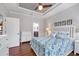 Well lit bedroom with hardwood floors, modern ceiling fan, a view to an ensuite bathroom at 5117 Serata Dr, Bradenton, FL 34211