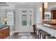 Bright foyer featuring a glass-accented door, wood floors, and views of the kitchen at 5117 Serata Dr, Bradenton, FL 34211