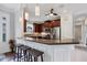 Kitchen boasts dark cabinets, stainless steel appliances, breakfast bar with stool seating and modern pendant lighting at 5117 Serata Dr, Bradenton, FL 34211