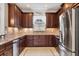 A kitchen features dark wood cabinets, backsplash, stainless steel appliances, and tiled floors at 5117 Serata Dr, Bradenton, FL 34211