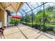 A covered patio with a decorative floor and table and chairs overlooks the manicured lawn at 5117 Serata Dr, Bradenton, FL 34211