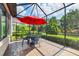 A screened patio features a table and chairs perfect for enjoying the manicured landscaping at 5117 Serata Dr, Bradenton, FL 34211