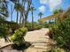 A paved patio surrounded by lush greenery and palm trees offers a relaxing outdoor space at 5207 86Th Street W Ct, Bradenton, FL 34210