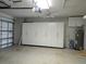 Spacious garage with white storage cabinets, ceiling fan and door opener at 5207 86Th Street W Ct, Bradenton, FL 34210