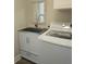This laundry area has a stainless utility sink with a cabinet and modern washing machine at 5207 86Th Street W Ct, Bradenton, FL 34210