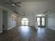 Open-concept living room showcasing wood floors, a ceiling fan, and ample natural light from an arched window at 5207 86Th Street W Ct, Bradenton, FL 34210