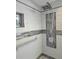 Shower featuring tiled walls, recessed shelf, grab bar, and a multi-setting shower head at 5207 86Th Street W Ct, Bradenton, FL 34210