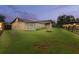 Backyard view showcases the enclosed patio and a fire pit under a colorful sunset sky at 5433 81St Avenue E Cir, Palmetto, FL 34221