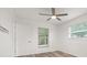 Bedroom featuring wood-look floors, neutral walls, ceiling fan, and large window at 5433 81St Avenue E Cir, Palmetto, FL 34221