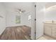 Bedroom with wood-look floors, ceiling fan, neutral walls, and an ensuite bathroom at 5433 81St Avenue E Cir, Palmetto, FL 34221