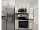 View of the kitchen featuring stainless steel appliances, tiled backsplash and white cabinetry at 5433 81St Avenue E Cir, Palmetto, FL 34221