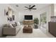 Bright living room with neutral decor, art, television, and sliding glass doors at 5433 81St Avenue E Cir, Palmetto, FL 34221