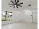 Bright living room featuring tiled floors, ceiling fan, and plenty of natural light from the windows at 5433 81St Avenue E Cir, Palmetto, FL 34221