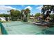 Aerial view of a green tennis court surrounded by mature trees and other neighborhood homes at 5433 81St Avenue E Cir, Palmetto, FL 34221