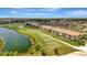 An aerial view shows a golf course community with condos and meticulously maintained green spaces near a serene lake at 5695 Palmer Cir # 203, Bradenton, FL 34211