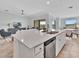 Kitchen island featuring stainless steel sink and dishwasher with adjacent living and dining areas at 5695 Palmer Cir # 203, Bradenton, FL 34211