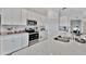 Bright kitchen featuring stainless steel appliances, white cabinets and quartz countertops at 5695 Palmer Cir # 203, Bradenton, FL 34211