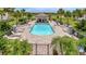 Community pool featuring a pool house, sun loungers, lush landscaping, and a secure gated fence at 5695 Palmer Cir # 203, Bradenton, FL 34211