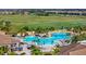 Aerial view of the pool featuring waterfalls, a sun deck, umbrellas, lounge chairs, and palm trees at 5695 Palmer Cir # 203, Bradenton, FL 34211