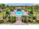 Community pool featuring a pool house, sun loungers, lush landscaping, and a secure gated fence at 5695 Palmer Cir # 203, Bradenton, FL 34211
